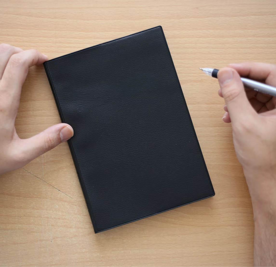 Duas m os seguram uma caneta e um caderno preto sobre uma mesa de madeira clara. Yapay zeka taraf ndan olu turulan a  klama