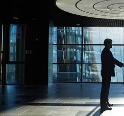 Two entrepreneurs handshaking in office center against window with sunlight penetrating inside